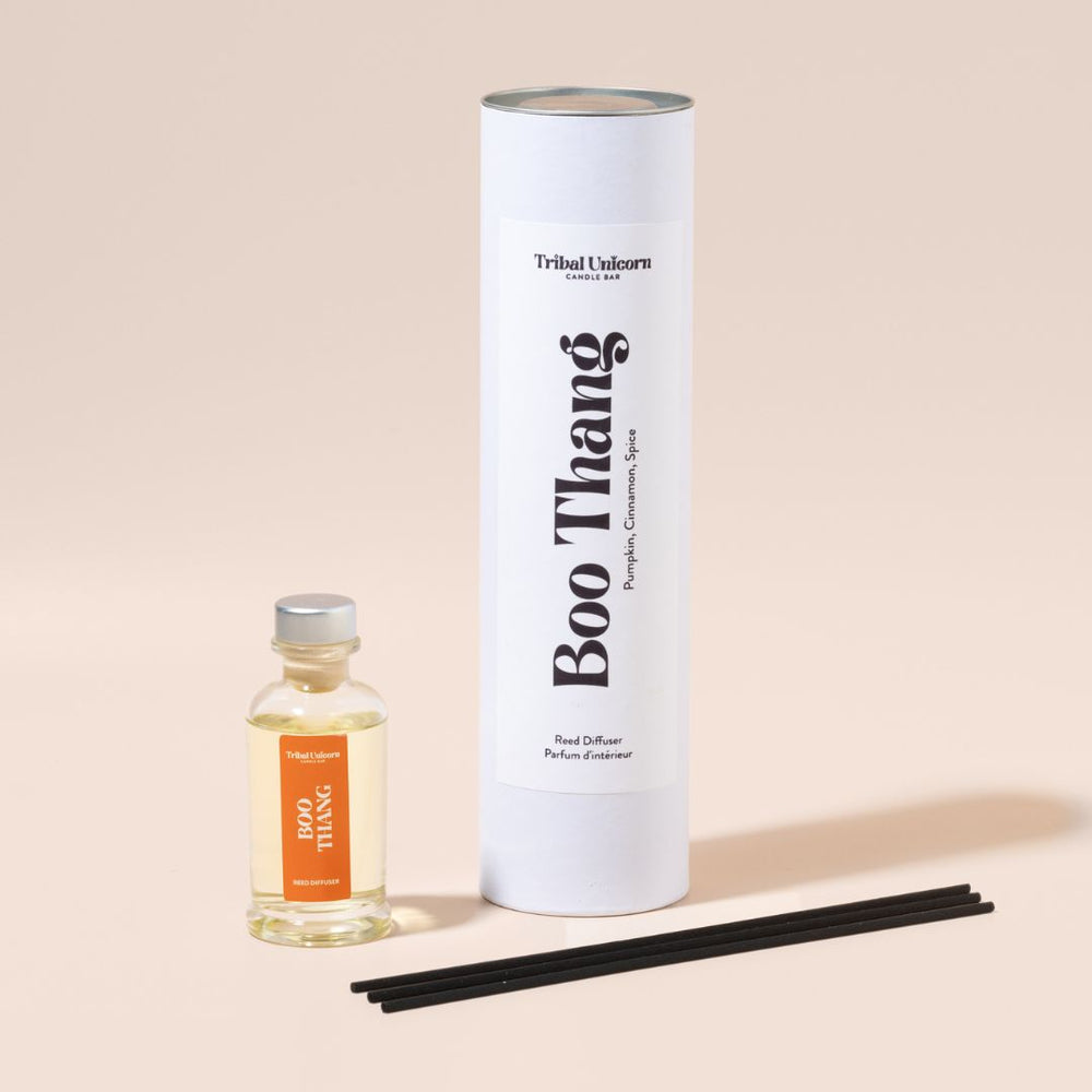 
                  
                    Boo Thang reed diffuser with bottle, diffuser sticks, and cylindrical packaging on a beige background
                  
                