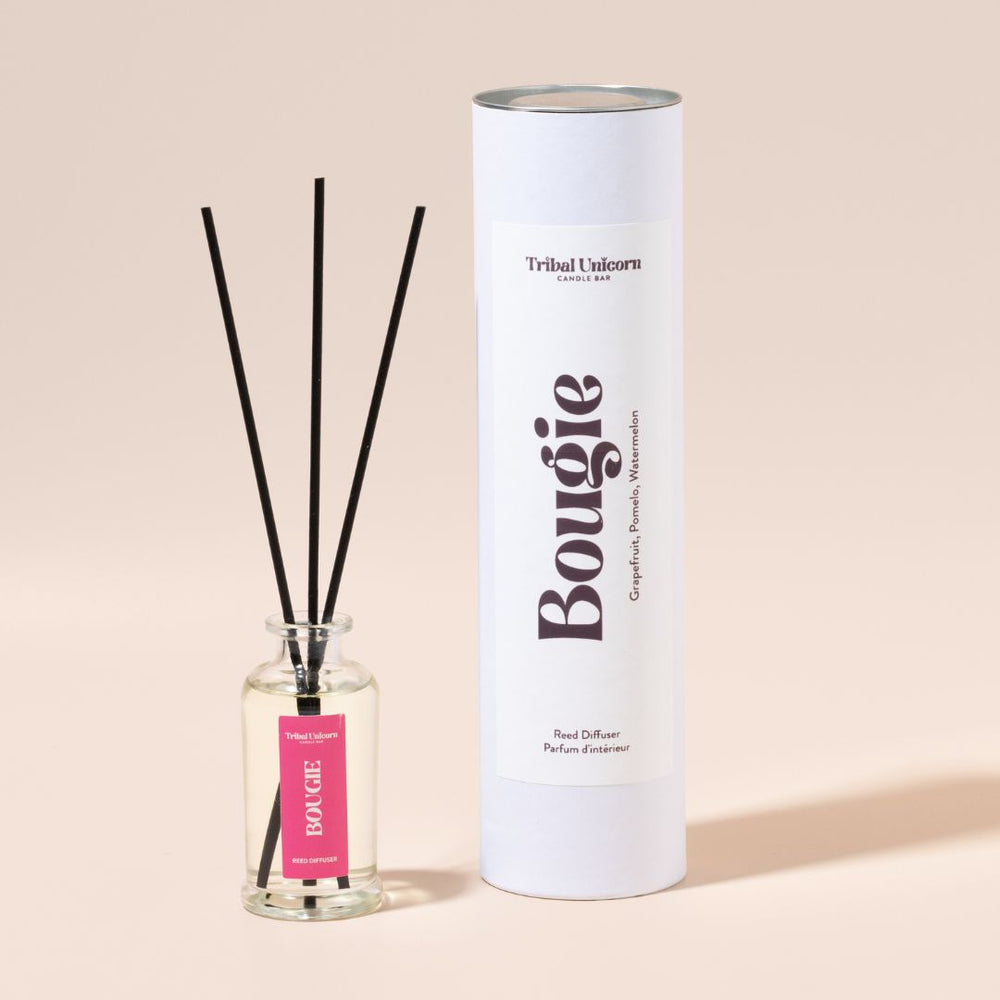 Bougie diffuser with reeds and cylindrical container on a beige background