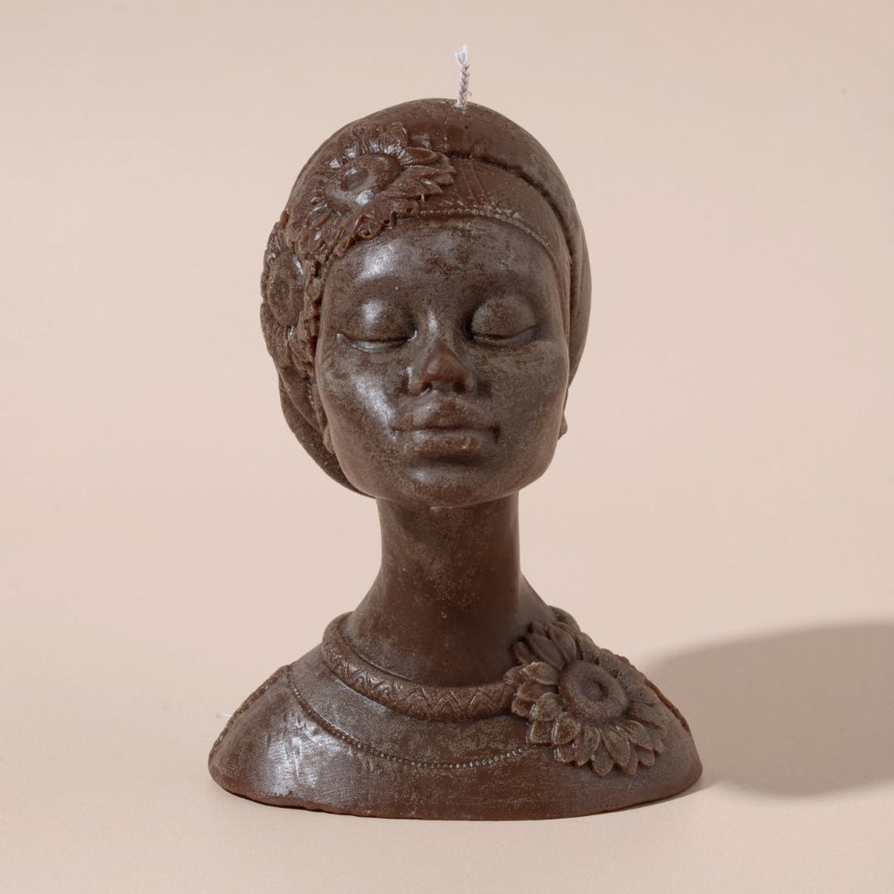 
                  
                    Bbust of a woman with decorative headpiece and necklace on a beige background
                  
                