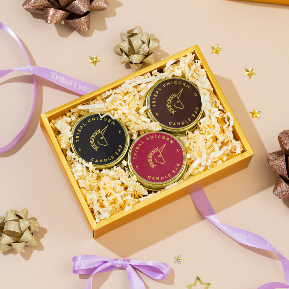 
                  
                    Three candles in a decorative box with ribbons and bows on a light background
                  
                